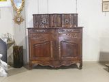 une armoire en bois dans une pièce où un miroir est accroché au mur
