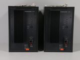 two black speakers sit side by side on a white surface