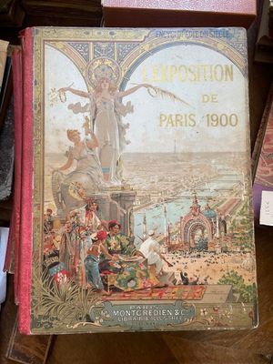 un vieux livre sur lequel figure l'image d'une femme, posé sur une table à côté d'autres livres