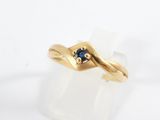 a close up of a gold ring with a sapphire stone