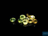 a close up of a bunch of green gems on a black surface