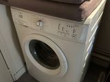 a dog that is laying on top of a washing machine