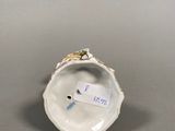 an antique porcelain figurine of a bird on a shell