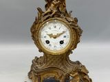 une horloge en or surmontée d'une statue
