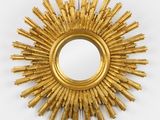 un miroir doré à rayons soleil accroché au mur, à côté d'un mur blanc