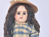 a doll that is wearing a hat and a plaid shirt