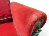 a red couch with a green rope on it