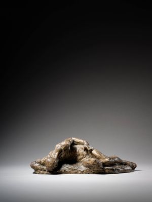 an image of a sculpture of a woman laying on a rock