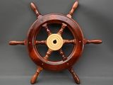 an image of a wooden ship wheel with a gold center