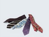 three different colored ties laying next to each other on a white surface