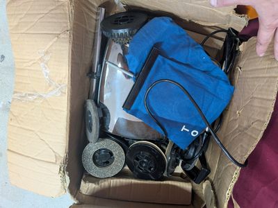 une personne tenant un sac bleu dans une boîte en carton