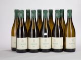 six bouteilles de vin sont alignées sur une surface blanche
