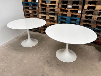 two white tables sitting next to each other in a room