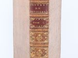 an old book sitting on top of a white surface