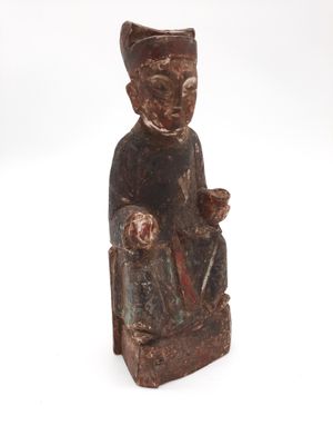 statue en bois représentant une femme tenant un bébé et un oiseau