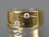 un gros plan d'une bague en or sertie de deux diamants