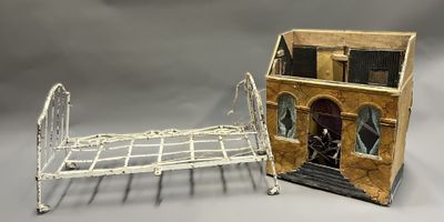 un lit miniature et une maison de poupées posés sur une table