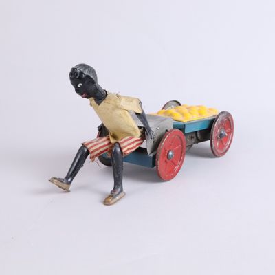 toy figurine of a man sitting on a cart with a basket of fruit