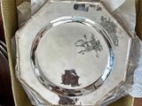 a silver plate in a box with a laptop on the table