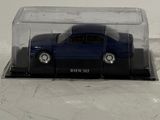 a blue toy car in a clear box on a white surface