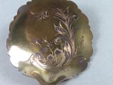 a silver plate with a design on it on a table