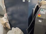une photo montrant une machine à laver et d'autres objets dans une pièce