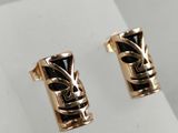 a pair of gold earrings with black stones on a white surface