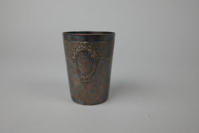un gros plan d'une tasse en métal posée sur une surface blanche