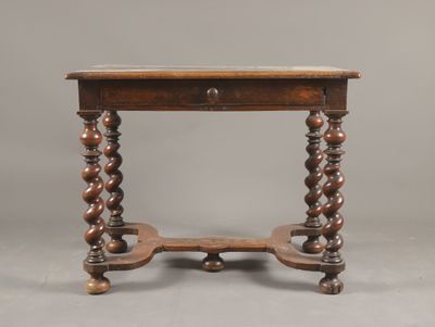 une vieille table en bois surmontée d'un tiroir
