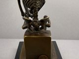 statue of a skeleton and a dog on a wooden base