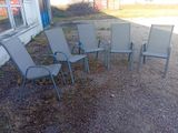 cinq chaises de jardin disposées en cercle devant un bâtiment