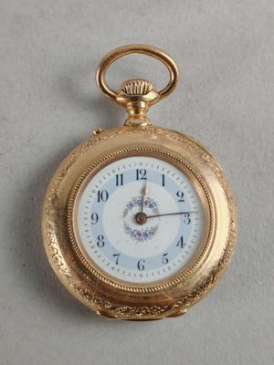 a gold pocket watch with a white face on a white surface