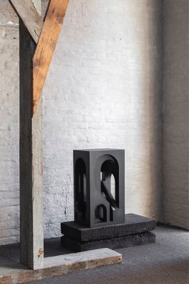 une sculpture posée par terre dans une pièce