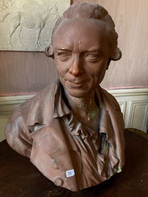 a bust of a man sitting on a wooden table