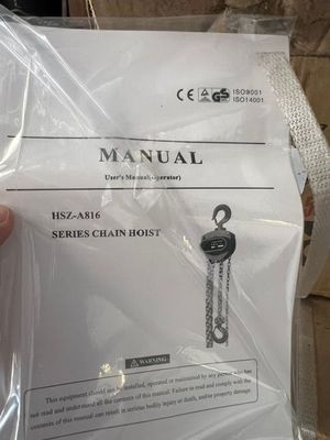 une personne tenant un manuel d'utilisation d'un palan à chaîne