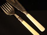 two forks and a knife sitting on top of a table