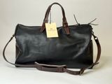 a black leather duffel bag with a tag attached to it