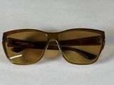 des lunettes de soleil marron posées sur une table blanche, sur fond blanc