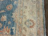 an image of a blue and beige rug with a floral design on it