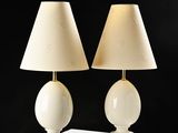 two white lamps on a white table with a black background