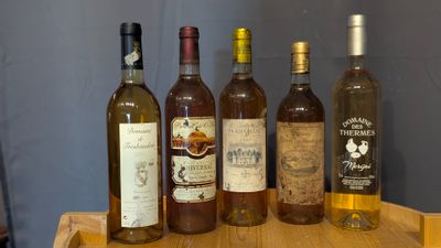 several bottles of wine are lined up on a wooden tray