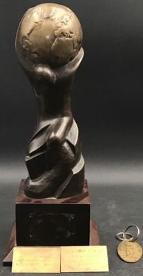une statue représentant une personne tenant un globe terrestre, posée sur un socle