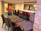 tables and chairs in a large room with a bar in the background