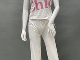 female mannequin wearing a white top and white pants with pink letters