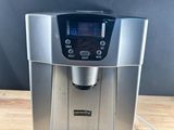 a silver coffee maker sitting on top of a wooden table