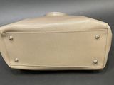 a white purse sitting on top of a table next to a black table