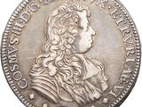 a silver coin with a portrait of a man with long hair