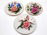 trois assiettes ornées de fleurs, posées sur un fond blanc