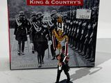 figurine représentant un homme en costume-cravate passant devant un groupe de soldats
