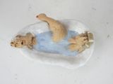a figurine of a woman in a bathtub with two dogs